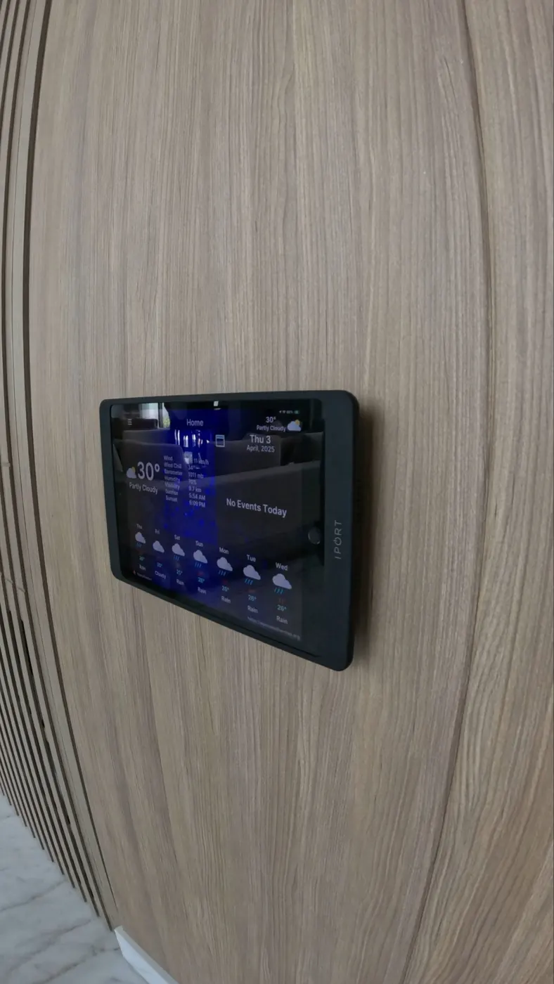 Pantalla táctil de control domótico empotrada en pared de madera