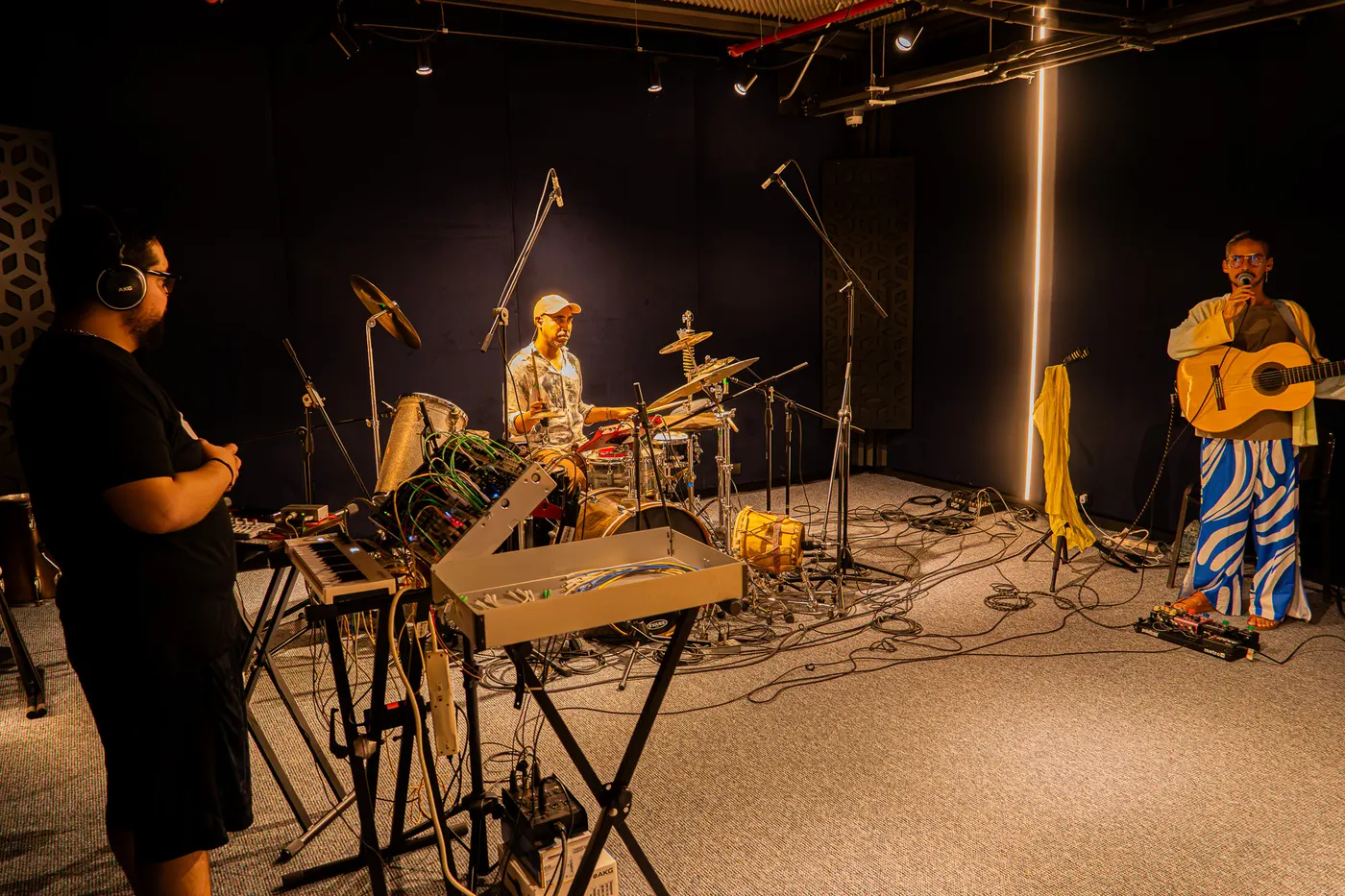 Sala de ensayo con músicos, sonido en vivo e iluminación de escenario