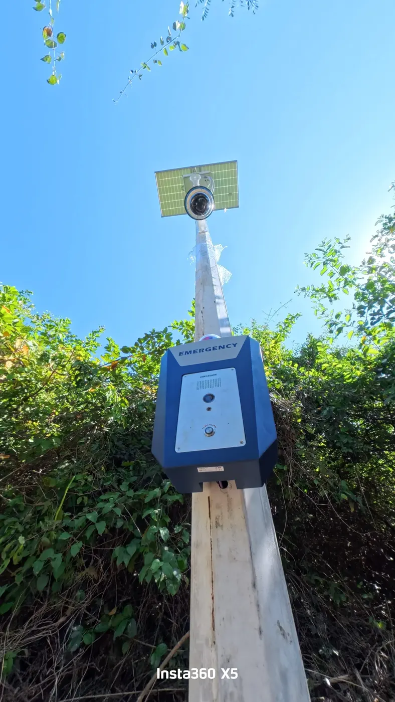 Cámara de seguridad exterior sobre poste con panel solar